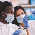 Two medical professionals look at test tube