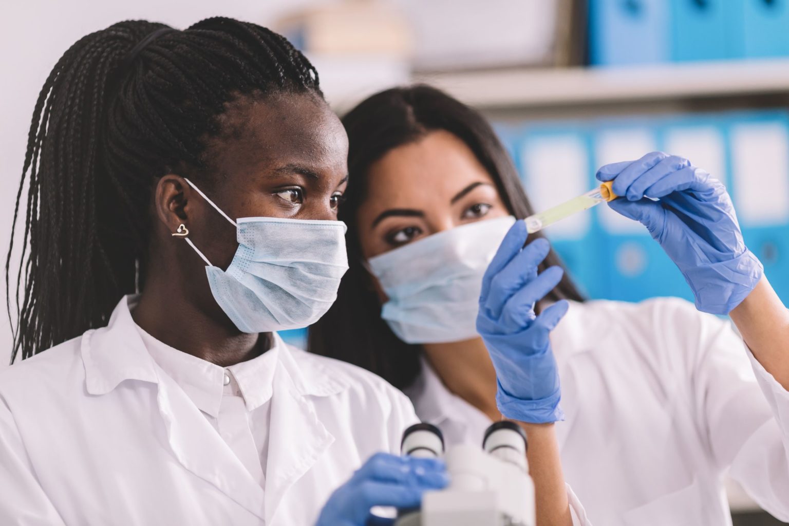 Two medical professionals look at test tube