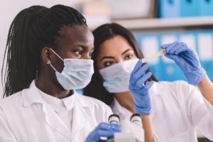 Two medical professionals look at test tube