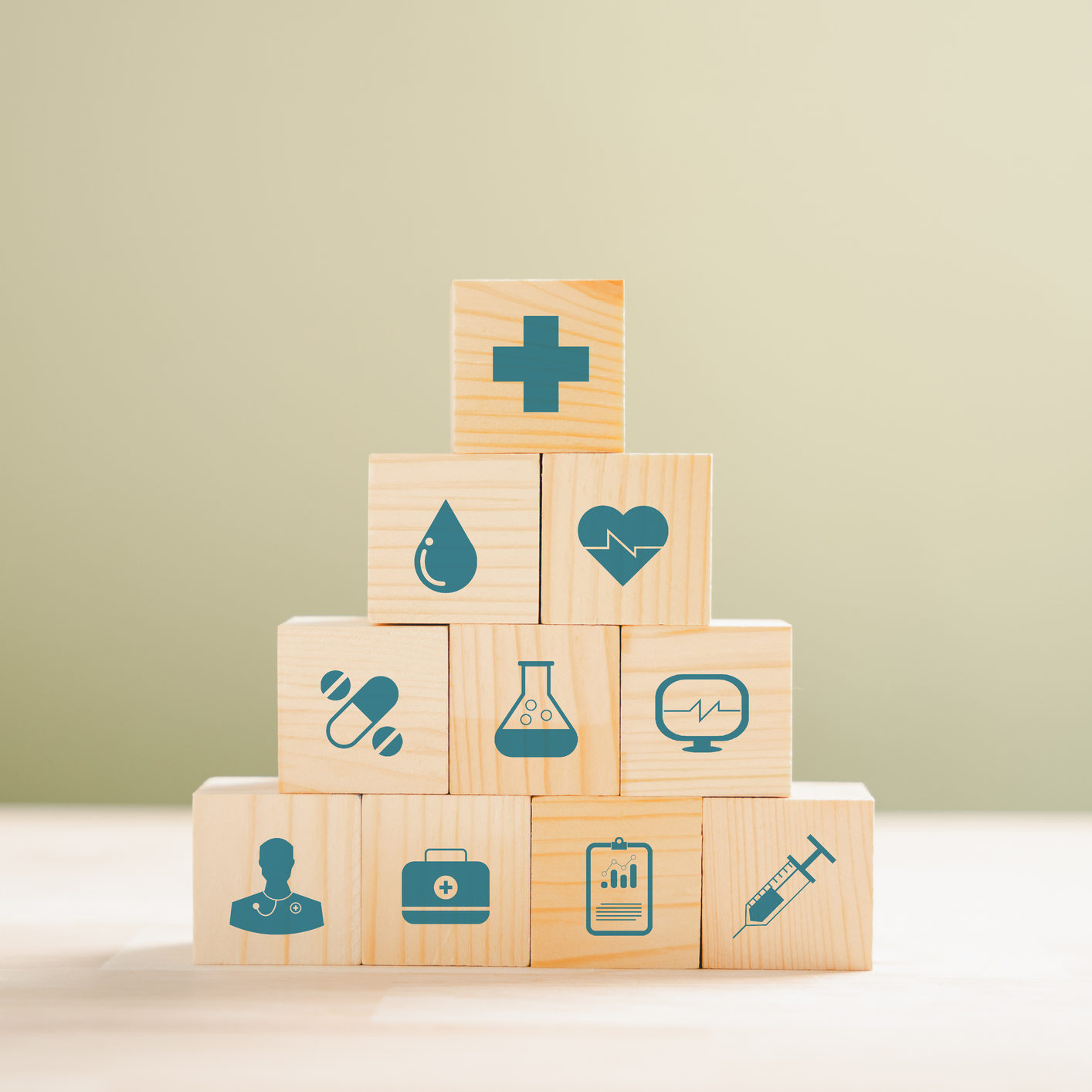 Healthcare and insurance concept depicted through a pyramid of wooden cubes. Crowned with a medical insurance icon atop a white background, creating space for Health Insurance message.